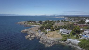 Havadan görünümü güzel bir Pasifik Okyanusu sahne ile kayalık sahil üstünde lüks evler. Sermaye Şehir Victoria içinde Vancouver Adası, British Columbia, Kanada, gündoğumu sırasında alınan.