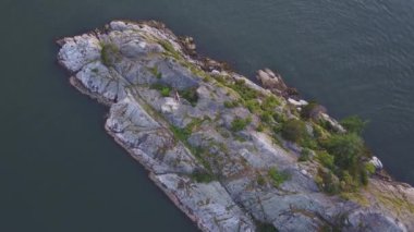 Havadan görünümü renkli bir gün batımı sırasında kayalık güzel kıyısında. Video alınan Whytecliff Park, Horseshoe Bay, Batı Vancouver, British Columbia, Kanada.