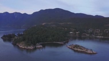 Havadan görünümü renkli bir gün batımı sırasında kayalık güzel kıyısında. Video alınan Whytecliff Park, Horseshoe Bay, Batı Vancouver, British Columbia, Kanada.