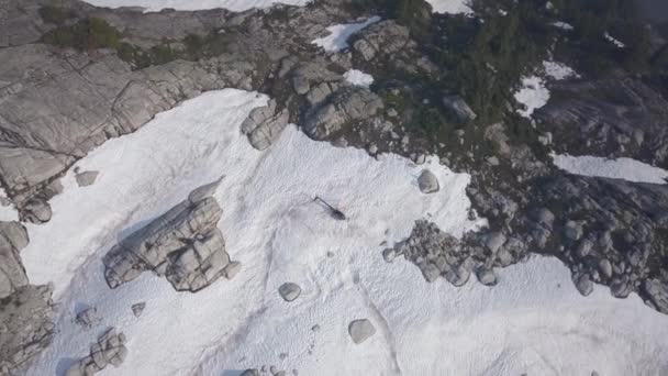雪の上にヘリコプターが付いている山の上に冷凍の氷河湖の空撮が上陸しました 北のバンクーバー ブリティッシュ コロンビア カナダを撮影したビデオ — ストック動画
