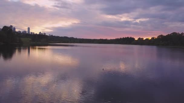 赤い色の空とカラフルで活気のある日没時に都市公園の湖の美しい空中映像 ディア レイク バーナビーより大きいバンクーバー カナダでの撮影 — ストック動画