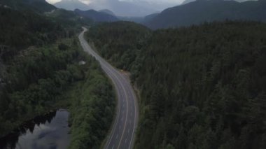 Havadan görünümü bulutlu gökyüzü ile bir yaz sabahı sırasında Kanada dağlarla çevrili bir güzel manzara otoyol rota üzerinde. Gökyüzü Hwy yakınındaki Whistler, Bc, Kanada için Denizde geçen.