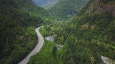Havadan görünümü bulutlu gökyüzü ile bir yaz sabahı sırasında Kanada dağlarla çevrili bir güzel manzara otoyol rota üzerinde. British Columbia, Kanada alınan.