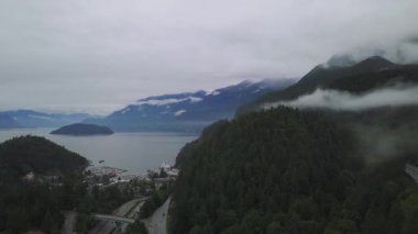 Havadan görünümü bulutlu gökyüzü ile bir yaz sabahı sırasında Kanada dağlarla çevrili bir güzel manzara otoyol rota üzerinde. Gökyüzü Hwy Horseshoe Bay, Vancouver, Bc, Kanada için Denizde geçen.