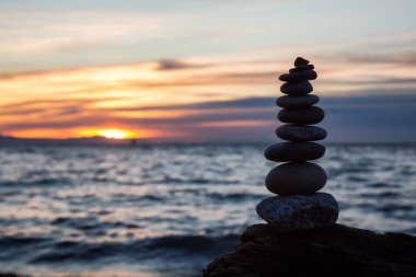 Taş yığını bir güneşli gün batımı sırasında okyanus ile yığılı. Batık Beach, Vancouver, British Columbia, Kanada alınan.