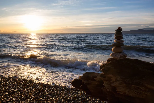 Stack of Rocks piled up by the ocean during a sunny sunset. Taken in Wreck Beach, Vancouver, British Columbia, Canada.