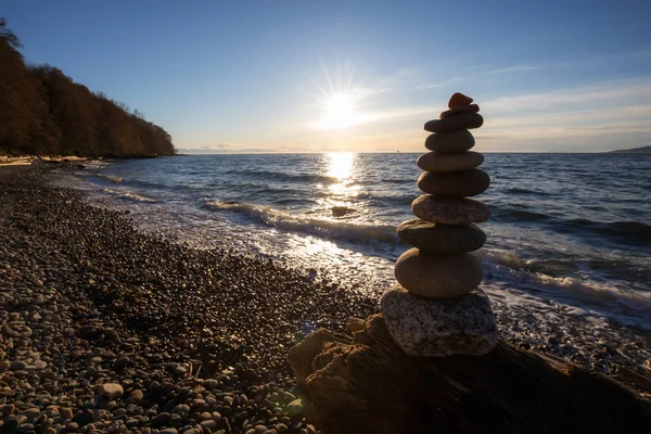 Stack of Rocks piled up by the ocean during a sunny sunset. Taken in Wreck Beach, Vancouver, British Columbia, Canada.