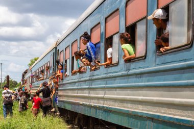 Ciego de Avila, Orta Küba - 14 Haziran 2019: Kübalı insanlar bulutlu ve güneşli bir yaz gününde küçük bir kasabada bir kaza sonrası treni bekliyorlar.