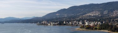 West Vancouver, British Columbia, Kanada. Pasifik Okyanusu kıyısında güneşli ve bulutlu bir sonbahar akşamında modern bir şehir manzarası..