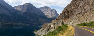Güzel Manzaralı Otoyol Manzarası. Arka planda Amerikan Rocky Dağı manzarası var. Bulutlu bir yaz sabahı boyunca. Buzul Ulusal Parkı, Montana, ABD 'de çekildi..