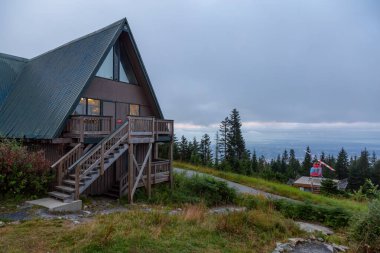 Kuzey Vancouver, British Columbia, Kanada. Renkli bir yaz gündoğumu sırasında Grouse Dağı 'nın tepesinde kırmızı helikopter..