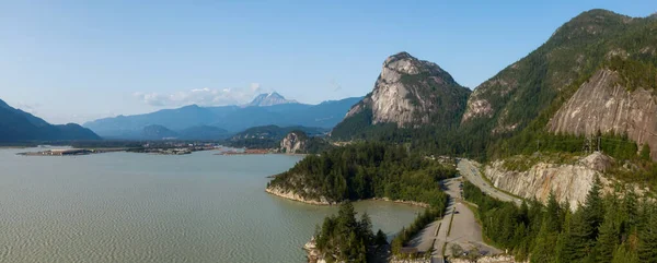Aerial panoramic view of Sea to Sky Highway with Chief Mountain in the background during a sunny summer day. Taken near Squamish, North of Vancouver, British Columbia, Canada.