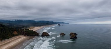 Cannon Sahili, Oregon, Birleşik Devletler. Güzel Hava Panoramik Manzarası Rocky Pasifik Okyanusu Sahili Bulutlu yaz gündoğumu sırasında.