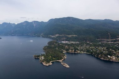 Horseshoe Bay, West Vancouver, British Columbia, Kanada. Yaz günü Kanada Dağ Manzarası ile çevrili kentteki evler, marina ve feribot terminali havadan izleniyor..