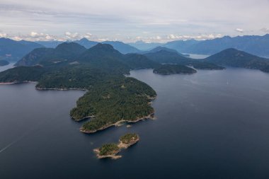 Keats Adası, Günışığı Sahili, British Columbia, Kanada. Bulutlu bir yaz akşamı Howe Sound 'daki bir adanın hava görüntüsü.
