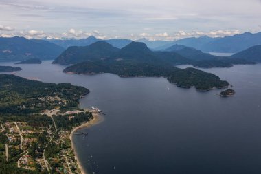 Gibson 'lar, Sunshine Coast, British Columbia, Kanada. Bulutlu bir yaz akşamı Howe Sound 'da küçük bir kasabanın hava görüntüsü.