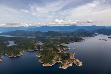 Sisli bir yaz gününde arka planda dağ manzaralı Nelson Adası 'nın havadan görüntüsü. Günışığı Sahili, Bc, Kanada.