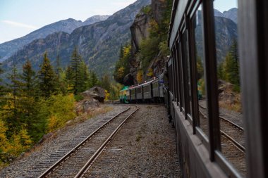 Skagway, Alaska, ABD - 24 Eylül 2019: Eski Tarihi Demiryolu Treni bulutlu bir yaz sabahı turistlerle birlikte Beyaz Geçit 'e çıkıyor.