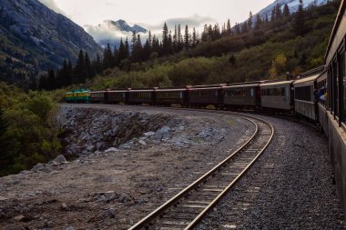 Skagway, Alaska, ABD - 24 Eylül 2019: Eski Tarihi Demiryolu Treni bulutlu bir yaz sabahı turistlerle birlikte Beyaz Geçit 'e çıkıyor.