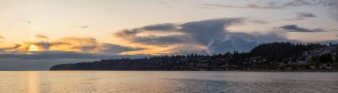 White Rock, British Columbia, Kanada. Güneşli ve bulutlu bir yaz günbatımında Okyanus kıyısındaki Evlerin Güzel Panoramik Manzarası.