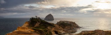 Cape Kiwanda, Pasifik Şehri, Oregon Sahili, Amerika Birleşik Devletleri. Okyanustaki Sandy Shore 'un bulutlu yaz günbatımında Güzel Panoramik Manzarası.