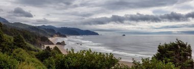 Ecola State Park, Cannon Beach, Oregon, ABD. Pasifik Okyanusu kıyısında bulutlu bir yaz gününde Sandy ve Rocky Sahili 'nin güzel panoramik manzarası.