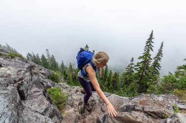Maceracı Kız bulutlu bir yaz sabahı dağlarda güzel yeşil ormanlarda yürüyüş yapıyor. Crown Dağı, Kuzey Vancouver, Bc, Kanada.