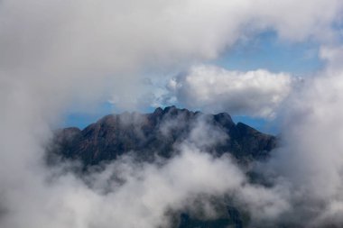 Canlı güneşli bir yaz gününde bulutlarla çevrili Arrowsmith Dağı'nın havadan görünümü. Nanaimo ve Port Alberni yakınlarında çekilmiş, Vancouver Adası, British Columbia, Kanada.