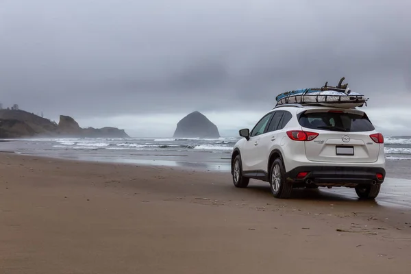 Pacific City, Oregon, Amerika Birleşik Devletleri. 8 Eylül 2019: Mazda CX-5, bulutlu bir yaz gündoğumu sırasında okyanus kıyısındaki kumlu sahilde at sürüyor..