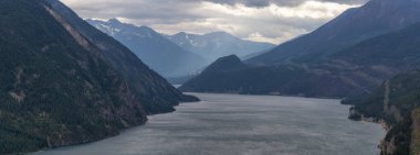 Aerial Panoramic View of Anderson Lake surrounded by Canadian Mountain Landscape during a cloudy summer day. Located near Lillooet, BC, Canada. clipart