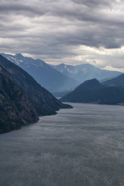 Anderson Gölü 'nün Kanada Dağ manzarasıyla çevrili havadan görüntüsü bulutlu bir yaz gününde. Lillooet, Bc, Kanada yakınlarında yer almaktadır..