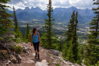 Maceracı Kız bulutlu bir yaz sabahı dağlarda güzel yeşil ormanlarda yürüyüş yapıyor. Crown Dağı, Kuzey Vancouver, Bc, Kanada.