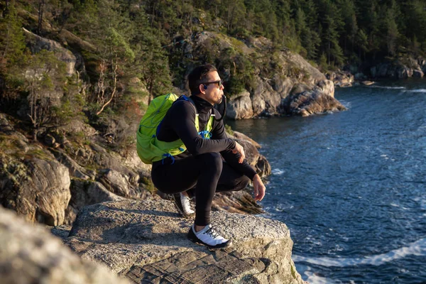 一个冒险犯难的拉丁男人在多云和阳光灿烂的日落下在大自然外喝水的画像 摄于加拿大不列颠哥伦比亚省温哥华市马蹄湾灯塔公园 — 图库照片