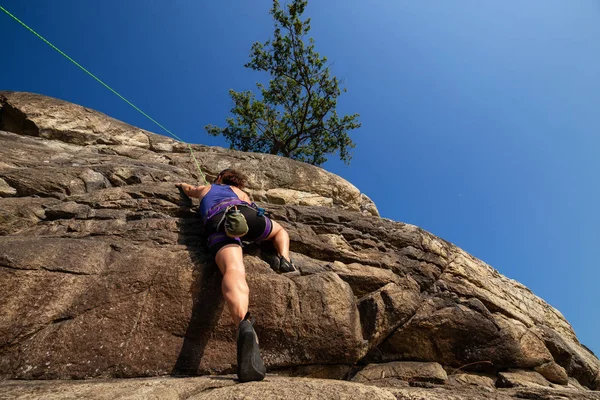 冒险女孩是在夏天的日落中攀岩爬上陡峭的悬崖 拍摄于加拿大不列颠哥伦比亚省西温哥华灯塔公园 — 图库照片