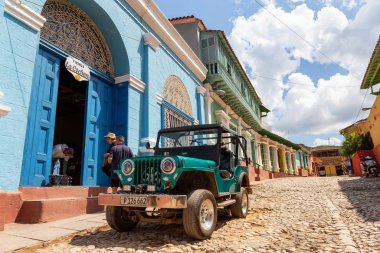 Trinidad, Cuba - June 6, 2019: View of an Old Classic American Car in the streets of a small Cuban Town during a vibrant sunny sunset. clipart