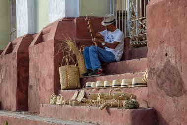 Trinidad, Küba - 12 Haziran 2019: Kübalı Adam güneşli bir akşamda Plaza Mayor yakınlarındaki sokaklarda sanat yapıyor.