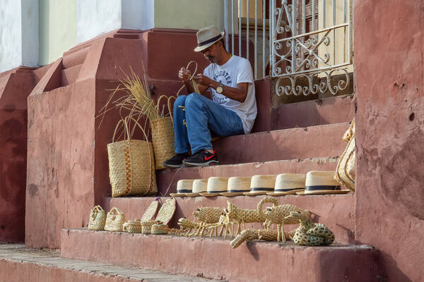 Тринидад, Куба - 12 июня 2019 года: Кубинский человек, занимающийся искусством на улицах возле площади Пласа-Майор во время яркого солнечного вечера
.