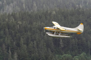 Juneau, Alaska, Birleşik Devletler. Yağmurlu bir sabahta küçük bir turistik kasabanın yakınında uçan yüzen uçak..