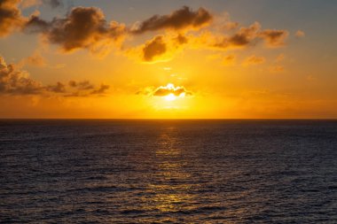Karanlık ve renkli bir turuncu gün batımında dramatik bir manzara. Barbados 'taki Karayip Denizi' nde çekildi..