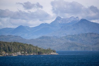 Kuzey Vancouver Adası, British Columbia, Kanada. Pasifik Okyanusu 'ndaki Rocky Adaları' nda güneşli ve bulutlu bir günde arka planda Adalar ve Anakara.