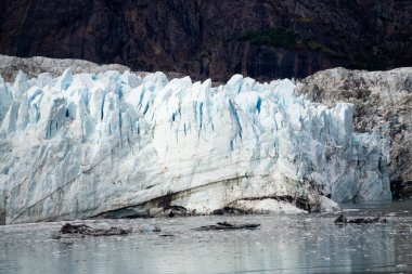 Margerie Buzulu 'nun okyanus kıyısındaki Amerikan Dağ Manzarası' ndaki güzel manzarası sonbahar mevsiminde bulutlu bir sabahta. Buzul Körfezi Ulusal Parkı ve Koruma Alanı, Alaska, Usa.