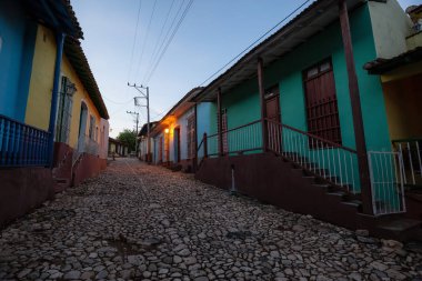 Trinidad, Küba - 9 Haziran 2019: Bulutlu ve güneşli bir gündoğumu sırasında küçük bir Küba kasabasındaki bir yerleşim yerinin sokak manzarası.