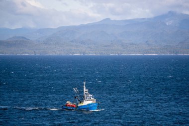 Kuzey Vancouver Adası, Britanya Kolumbiyası, Kanada - 27 Eylül 2019: Pasifik Okyanusunda balıkçı teknesi, arka planda Adalar ve Anakara ile güneşli ve bulutlu bir günde.