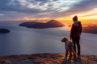 Maceracı Kız bir köpekle dağın tepesinde yürüyüş yapıyor.