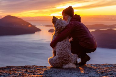 Maceracı Kız bir köpekle dağın tepesinde yürüyüş yapıyor.
