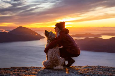 Maceracı Kız bir köpekle dağın tepesinde yürüyüş yapıyor.