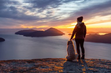 Maceracı Kız bir köpekle dağın tepesinde yürüyüş yapıyor.