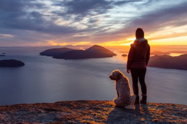 Maceracı Kız bir köpekle dağın tepesinde yürüyüş yapıyor.