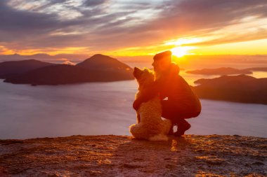 Maceracı Kız bir köpekle dağın tepesinde yürüyüş yapıyor.