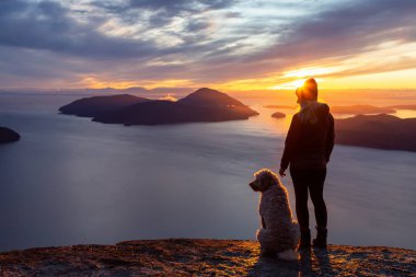 Maceracı Kız bir köpekle dağın tepesinde yürüyüş yapıyor.